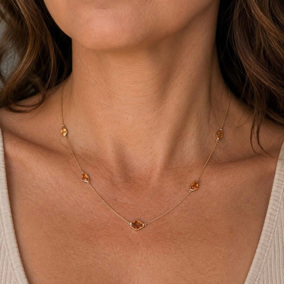 A close-up of a model wearing our Ember Portrait Necklace. 